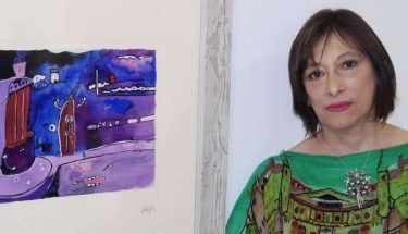 La artista chilena Alexandra Domínguez, con fuertes vinculaciones leonesas, posa junto a una de las obras de la exposición. © CUEVAS.